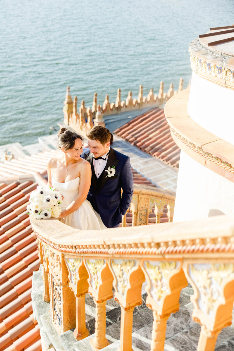 Bride and groom sharing a quiet moment on a Moorish-style waterfront balcony at the Ringling Museum in Sarasota — Tampa Bay wedding photographer Ailyn La Torre