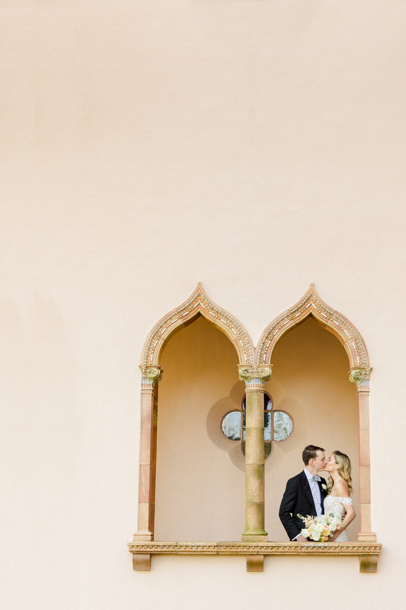 Couple kissing within an ornate Moorish arch at the Ringling Museum in Sarasota — Tampa Bay wedding photographer Ailyn La Torre